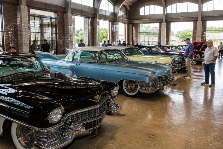 Collection de modèles Cadillac Fleetwood d'époques variées exposés dans un hall de voitures classiques.