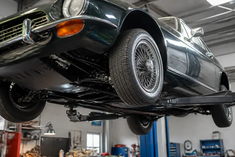 Inspection d'un châssis d'aston martin vintage sur un pont élévateur en atelier