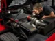 Un mécanicien examine le moteur V8 biturbo d'une voiture de collection f40 dans un atelier spécialisé
