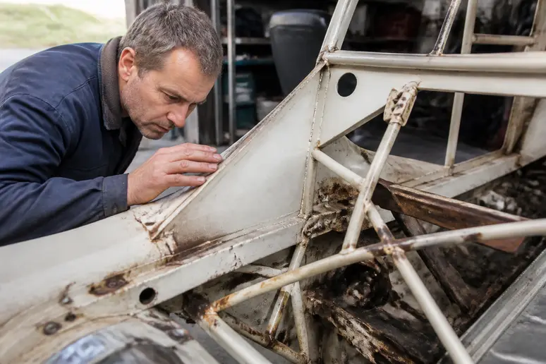 Inspection minutieuse des tôles soudées et du châssis d'une mini moke d'occasion pour repérer la rouille.