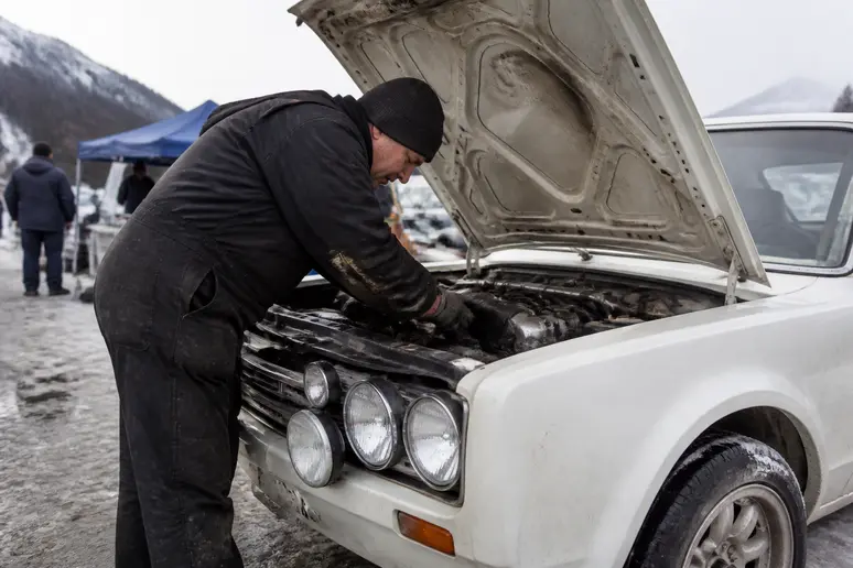 Mécanicien préparant le moteur d'une voiture ancienne pour le monte carlo historique 2026.