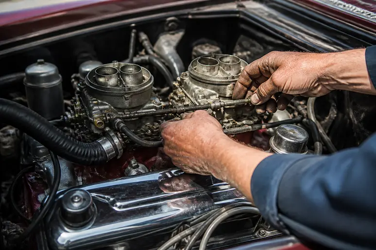 Réglage précis des carburateurs sur le moteur V8 d'un range rover classic de collection.