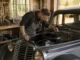 Un mécanicien examine le moteur d'une juvaquatre ancienne dans un atelier de restauration automobile