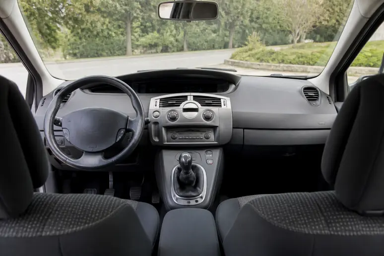 Vue de l'habitacle et du tableau de bord d'un Renault Scénic II bien entretenu.
