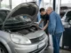 Un mécanicien examine le moteur ouvert d'un scenic 2 dans un atelier de réparation automobile