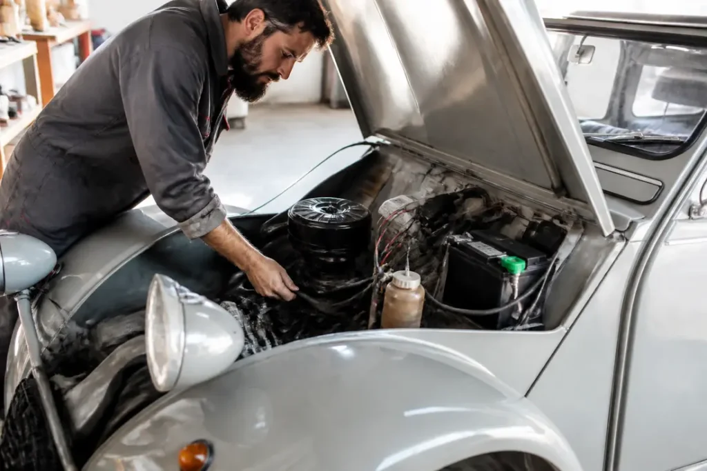 Un mécanicien effectuant la remise en route 2CV dans un atelier lumineux